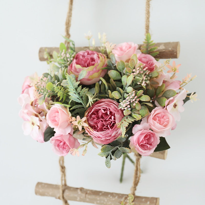 Handmade artificial silk peonies and roses bouquet.  Light blush pink and medium pink blooms with greenery displayed in a wall hanging of natural birch wood and rope.