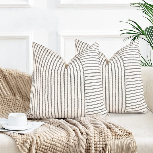 Striped Farmhouse Style Pillow Cover placed on a sofa in a living room.  Shown here in the black stripe with creamy white background.