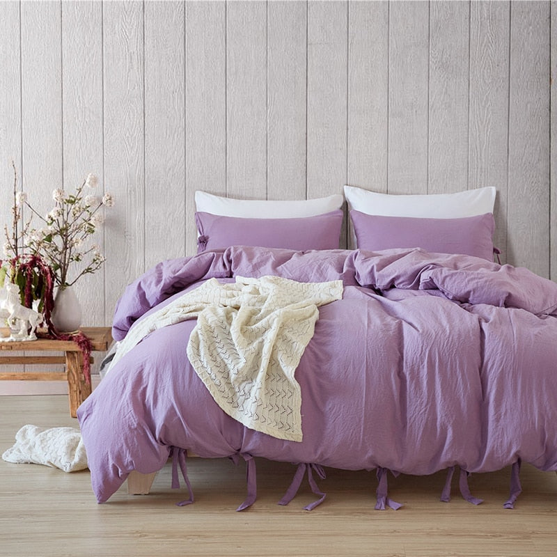 Bowtie Lace Up Duvet Cover set in lilac styled in a bedroom with matching pillow shams.