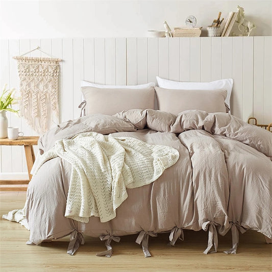 Bowtie Lace Up Duvet cover set in Ecru color layered with throw blankets and matching pillows.  