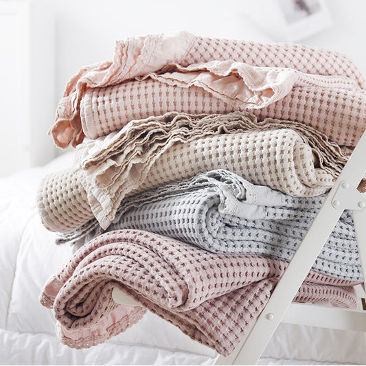 100% Cotton, waffle weave knit design blankets.  Available in 4 solid colors, pink, beige, deep pink, and grey.  3 available sizes.  This sturdy, easy care blanket is completed with a ruffled edge.