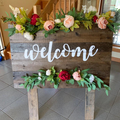 Soft peach, burgundy and cream white European Silk Peonies as shown on a welcome sign as a piece of wedding decor.