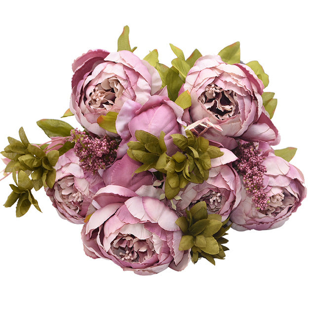 1 bunch of dark pink European Silk Peonies complete with muted green leaves.